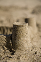 A sand castle at the beach made with inverted cups