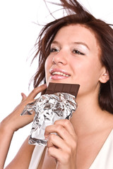 The young beautiful girl eats chocolate.