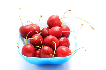 Bowl of fresh red cherries, isolated on white shot in studio