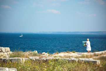 Woman painter during creation on sea side