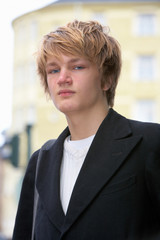 Fototapeta premium Portrait of teenage boy in street, low angle view