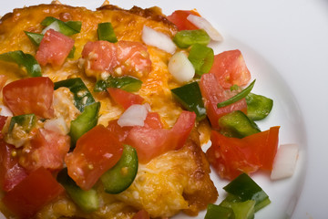 mexican burrito covered in fresh vegetables and melted cheese