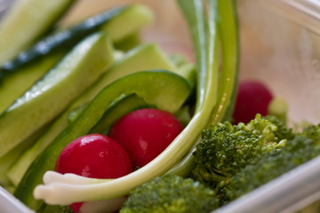 fresh vegetables cut up and in a plastic bowl