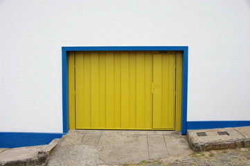 Porte de garage jaune sur mur blanc. Brésil.