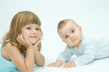 little brother and sister playing together, on white
