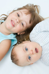 little brother and sister playing together, on white