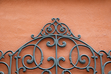 Decorative Wrought Iron Against Bright Colored Stucco Wall