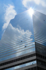 Blue sky with cloud and sun reflection on skyscraper