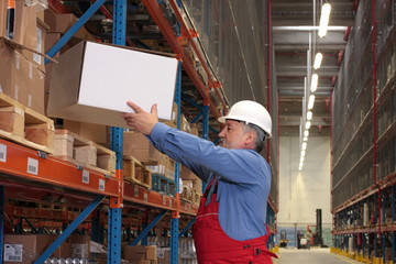 senior worker in uniform putting box on shelf in warehouse