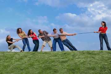 Group of happy people pulling the rope
