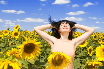 Obraz na płótnie Canvas fun woman in the field of sunflowers