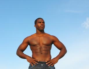 Handsome muscular male on a blue sky