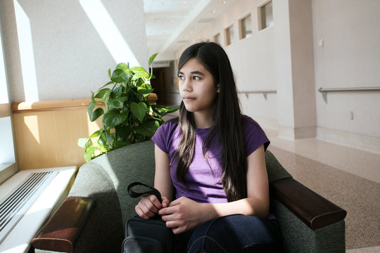 Young teen girl in waiting room, worried expression