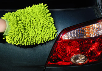 woman's hand in washmitt washing stop light of an SUV