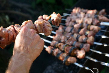 An image of chunks of meat cooking on barbeque grill