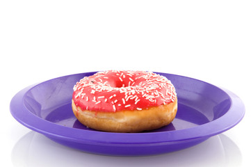 Pink doughnut on purple plate