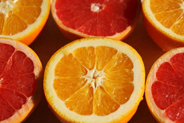 Fototapeta na wymiar Oranges and red grapefruit halves lying in the chess order.