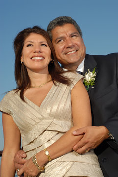 Older Hispanic Couple Embracing Each Other And Smiling