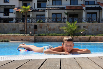 The boy next to the swimming pool.