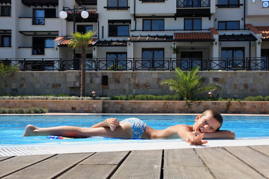 The boy next to the swimming pool.