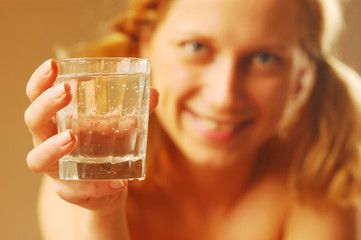 A blond young woman with glass of water