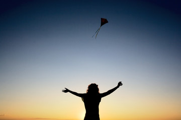 a woman with kite at dawn