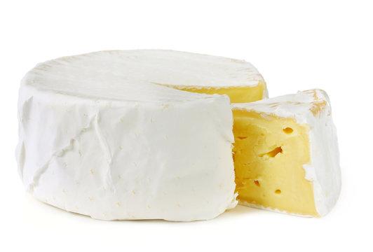 A wheel of rich creamy brie cheese, with a wedge cut out.