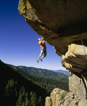 Rock climber dangling from a cliff.
