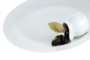 Black olives on white service plate, beauty of black
