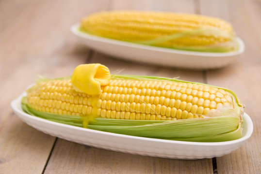 Corn on the cob sweetcorn in dishes on a rustic table