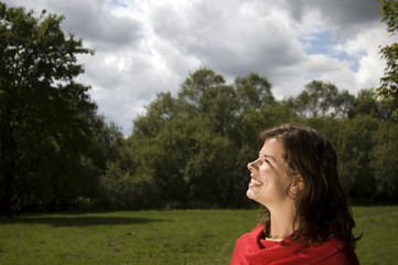 Loving life. Happy girl looking on puffy clouds