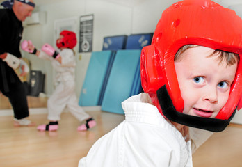 Young boy in karate saftey gear in dojo