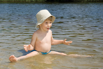 little boy play on the river bank