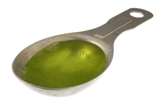 measuring tablespoon of green dish washing detergent