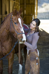 Obraz premium Cowgirl and horse getting ready for a ride.