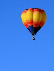 Colorful hot air balloon in blue sky with plenty of copy space