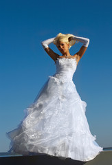 Fototapeta na wymiar Blonde bride on blue sky background
