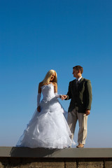 Bride and fiance on blue sky background