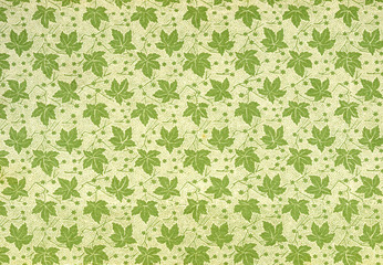 Used vintage wallpaper with leaves, grainy surface