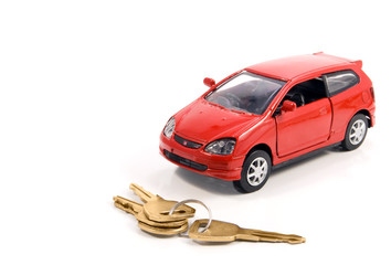 Toy car and keys over white. Rent or buy car concept