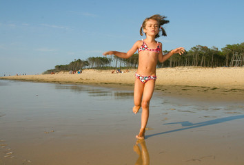 Naklejka premium fillette courant sur la plage 3