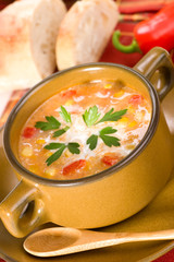 Bowl of corn and red chilli chowder with cream and parsley