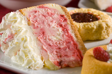 A slice of strawberry cheesecake with whipped cream.