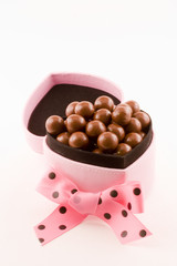 A pink box stuffed full of chocolates.