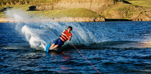 A male waterskiing on a lake in the evening