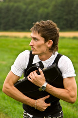 Fototapeta premium Treasure concept - young man holding this bag and looking round