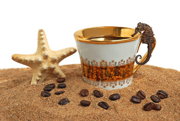 Gold cup with coffee and beans on a sea beach