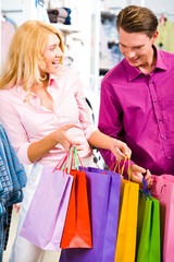 Portrait of cheerful woman showing presents to her boyfriend