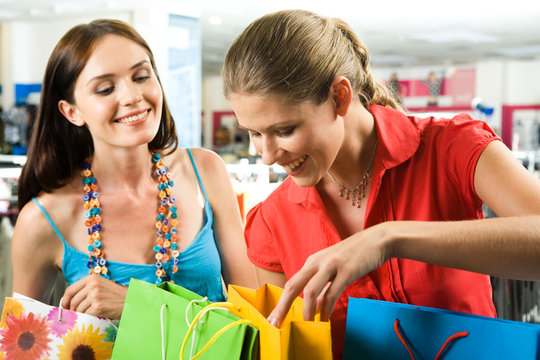 Photo of two friends looking through their shoppings