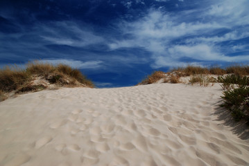 Blue sky over dune and small passage